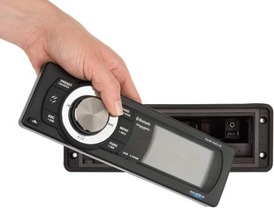 Hand holding Bluetooth audio receiver with display and control buttons.