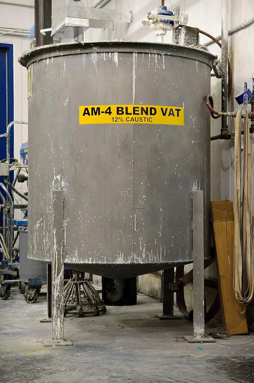 Large metal AM-4 Blend Vat with a yellow label in an industrial setting