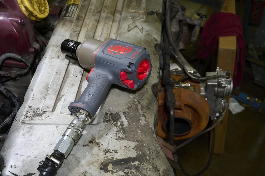 Gray and red impact wrench on a workbench in a workshop setting