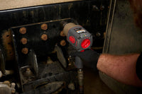 Person using a red and gray impact wrench on a mechanical component.