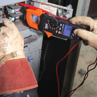 Person using a digital clamp meter
to measure voltage on electrical equipment.
