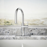 Modern kitchen faucet on a marble countertop with a neutral background