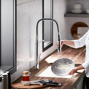 Person using a kitchen faucet with a modern kitchen setting