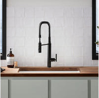 Kitchen faucet over a wooden countertop with a tiled wall background