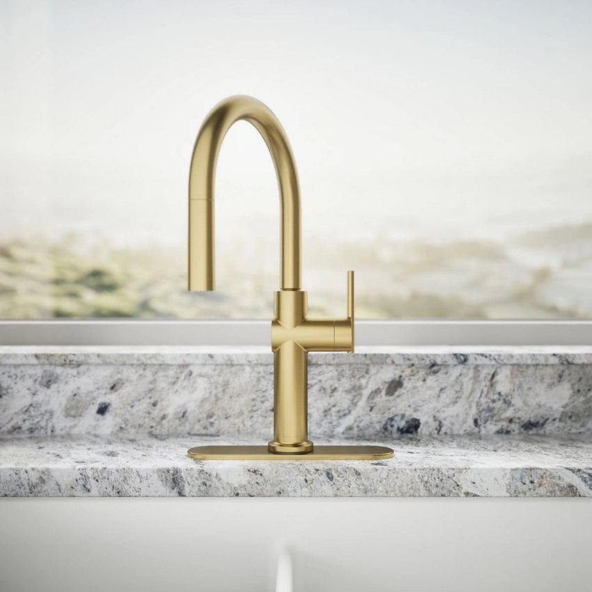 Gold kitchen faucet on a marble countertop with a neutral background
