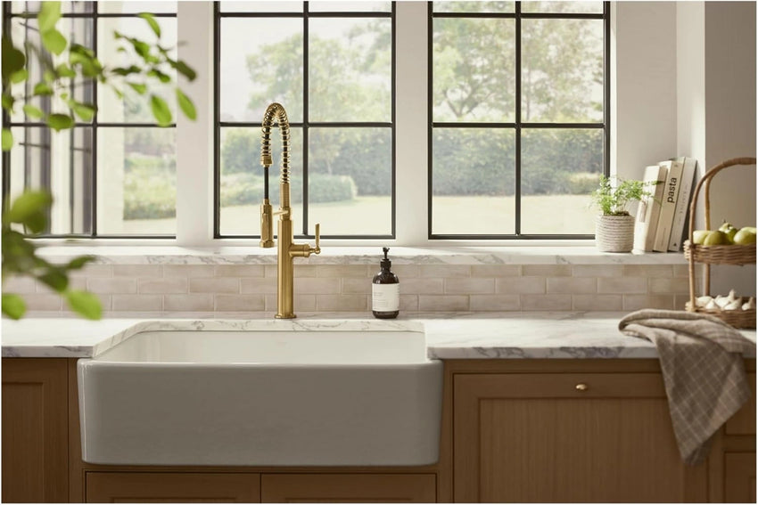 Modern kitchen with a white sink, faucet, and large windows.