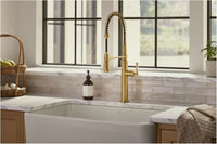 Kitchen faucet over a white sink with a window in the background