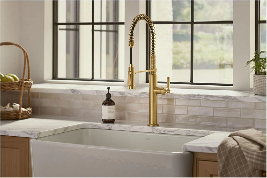 Kitchen faucet over a white sink with a window in the background