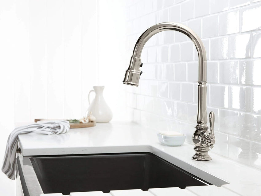 Modern kitchen sink with a silver faucet against a white tiled wall.