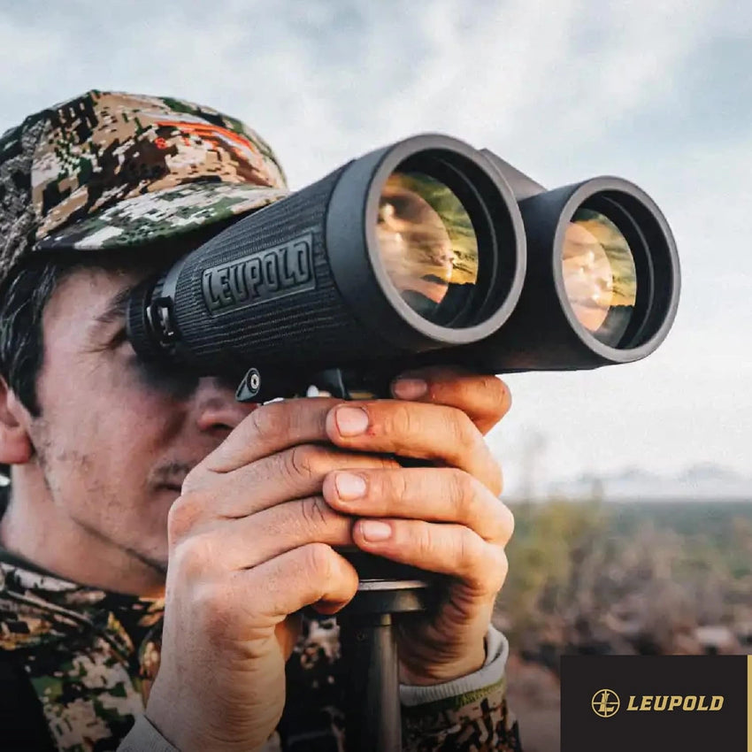 Person using Leupold binoculars in a natural setting