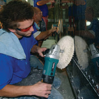 Person using a polishing machine on a large mirror