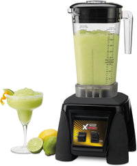 Blender with a green smoothie and a glass on a white background